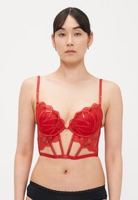 Lingerie vermelha com tecido de rede transparente, design de renda floral e detalhes decorativos dourados. Possui alças ajustáveis e estilo com recortes.