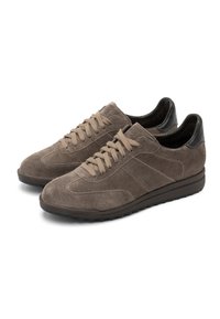 Sneakers low-top in suede marrone con lacci abbinati, dettagli in pelle nera sul tallone e suola in gomma testurizzata. Design semplice e sportivo.