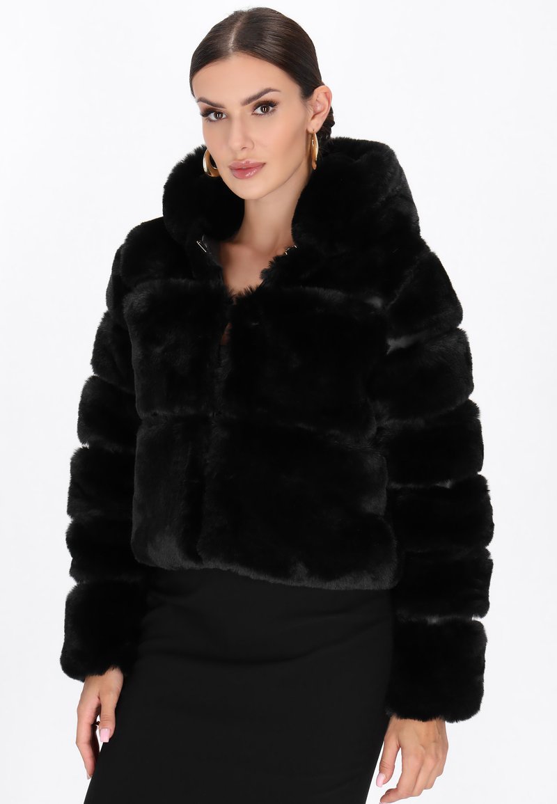 Sort faux fur cropped jakke med hætte, der har en blød tekstur og lynlås lukning. Boksformet design med brede ærmer og et lagdelt udseende.