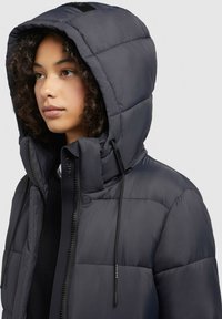 Dark puffer jacket with a large hood, made from shiny material. Features a quilted design, adjustable drawstrings, and a front zipper.