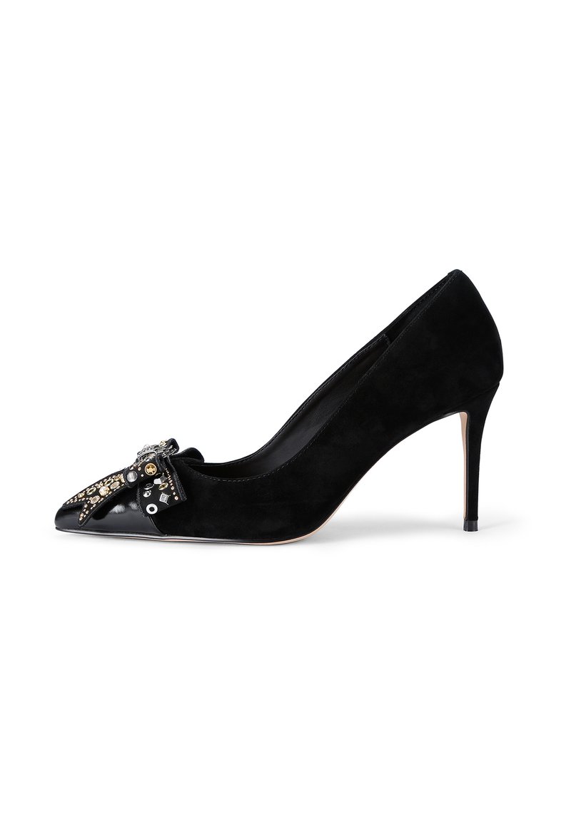 Escarpin noir en daim à talon haut avec un bout pointu, présentant un accent en cuir verni noir brillant et des embellissements décoratifs sur l'avant.