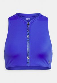 Top desportivo azul curto, com decote redondo e fecho de zip. Apresenta uma faixa com o logótipo a correr pelo centro em amarelo e preto contrastantes.