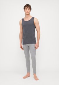 Szürke trikó és világosszürke, testhezálló leggings, puha anyagból készült. A trikó kerek nyakú; a leggings a bokáig ér.