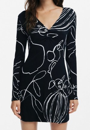 Robe noire à manches longues avec un col en V, présentant des dessins abstraits blancs de botanique et de vases en lignes.