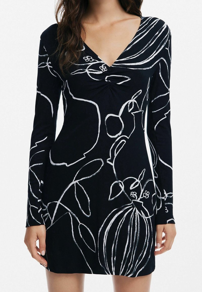 Robe noire à manches longues avec un col en V, présentant des dessins abstraits blancs de botanique et de vases en lignes.