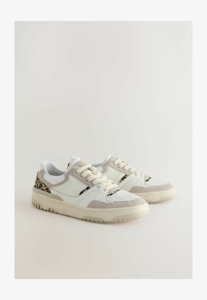 Bijele tenisice s bež suede detaljima i leopard uzorkom na peti. Imaju okrugle vezice i rebrastu gumenu potplat.