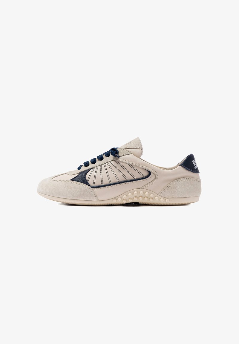 Baskets décontractées beige et marine avec détails cousus, lacets marines, semelle texturée et logo sur la partie talon, vues de profil.
