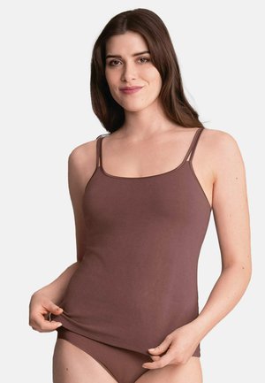 Young woman with long brown hair wearing a brown camisole and matching underwear, slightly lifting the hem of the camisole.