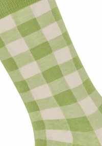 Zielono-kremowe skarpetki w kratę o miękkiej teksturze dzianiny, z naprzemiennymi kwadratami i prążkowanym mankietem na górze.
