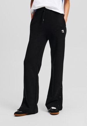 Zwarte sweatpants met een trekkoord in de taille, zijzakken en drukknoopjes aan de onderkant. Zachte stof met een subtiele logo-detail aan de voorkant.