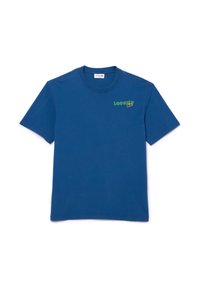 Camiseta de algodón azul con mangas cortas, escote redondo y logotipo verde de "Lacoste" en el lado izquierdo del pecho. Textura suave, ajuste estándar.