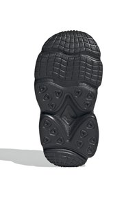 Black sneaker outsole with textured rubber, featuring a patterned tread and various geometric shapes for grip and support.