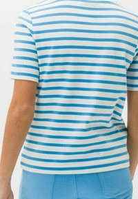 Lyhythihainen raidallinen t-paita vaaleansinisessä ja valkoisessa, pehmeästä materiaalista valmistettu. Siinä on vaakasuoria raitoja ja istuva malli.