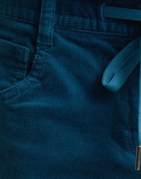 Teal corduroy pants feature a textured surface, a front pocket, and a matching fabric tie for an adjustable waist.