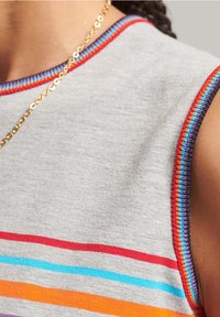Šedý top bez rukávů s horizontálními pruhy v červené, modré, oranžové a fialové barvě. Okraje mají vícebarevné prošití.
