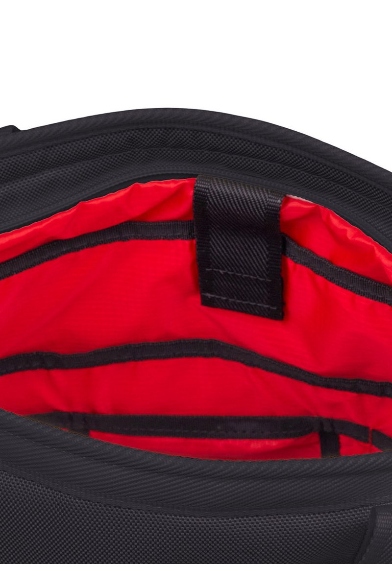 Der Innenraum des schwarzen Rucksacks ist mit einem roten Futter ausgestattet und verfügt über Organisationsfächer sowie einen zentralen Gurt zum Sichern von Gegenständen. Außenmaterial aus strukturiertem Stoff.