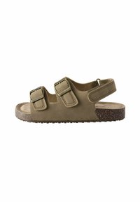 Olivengrønne sandaler med to justerbare spænder, en blød sål og en struktureret korksål med flad design.