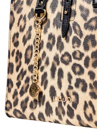 Borsa a stampa leopardata con superficie texturizzata, dettagli neri, catena dorata e logo impresso sul davanti.