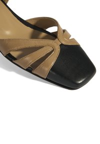 Braun und schwarze Leder-Sandalette mit quadratischer Zehenpartie, die über Kreuz verstellbare Riemen und Stickdetails auf dem Oberteil verfügt. Strukturierte Sohle.