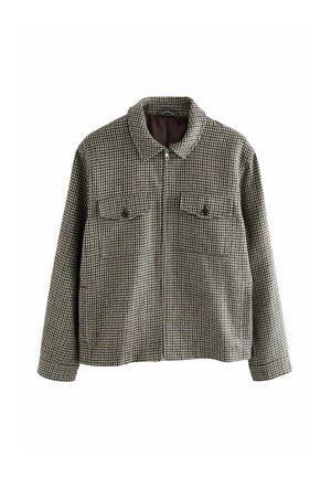 Plaid jacket in black and cream with a zip closure, spread collar, and two chest pockets. The textured fabric features a houndstooth pattern.