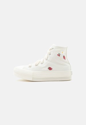 White high-top canvas sneaker with embroidered strawberries, cherries, and daisies on the side, featuring white laces and a thick sole.