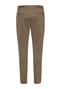 Pantalons marron ajustés en tissu texturé, coupe slim, et deux poches arrière. Dotés d'une taille avec passants de ceinture et de accents matériels minimalistes.