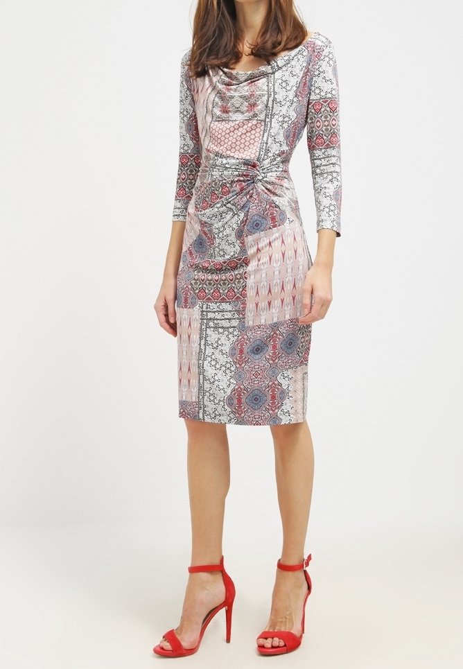 Musterkleid mit einem Schalkragen, Dreiviertelärmeln und geraffter Seite. Es präsentiert eine Mischung aus roten und grauen Blumenmustern.