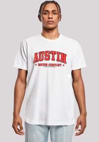 White cotton t-shirt featuring bold red text "AUSTIN MOTOR COMPANY" in distressed font, round neck, short sleeves, and relaxed fit.