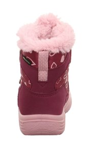 Růžové zimní boty s měkkým kožíškem, zdobené bílými srdíčky, a odolnou tkaninou. Mají pevnou podrážku a suchý zip.