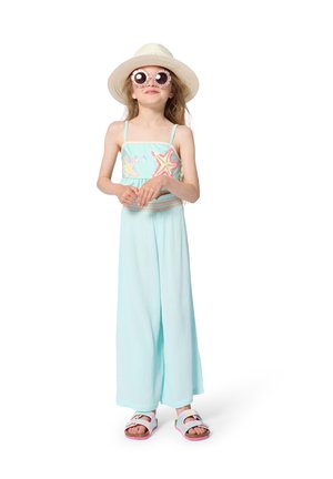 Young girl wearing a sunhat, round floral sunglasses, a light blue starfish-patterned top, wide-legged pants, and white sandals.