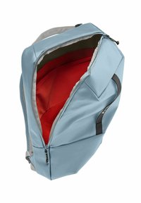 Sac à dos bleu avec un extérieur texturé, un intérieur rouge et une doublure grise. Il est équipé d'une fermeture éclair et d'une poignée latérale pour le transport.