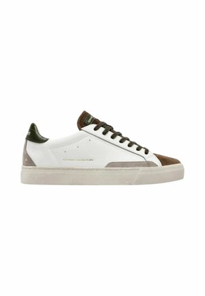 Sneaker bianca low-top con punta in camoscio marrone, lacci marrone scuro, linguetta verde sul tallone e suola beige, marchiata con "Crime London" sul lato.