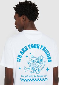 Witte katoen t-shirt met blauwe grafische tekst en cartoonfiguren van voedselitems op de achterkant, met "We Are Your Friends" en een dambordpatroon.