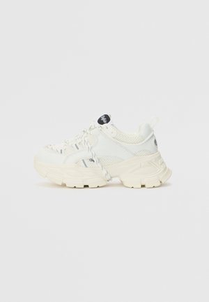 Weiße Sneakers mit einem strukturierten Mesh-Obermaterial, massiver Sohle und gestreiften Akzenten. Mit geflochtenen Schnürsenkeln und einem schwarzen Logo auf der Zunge.