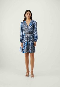 Kleid mit blau-schwarzem Tiermuster, langen Puffärmel, tiefem V-Ausschnitt und tailliertem Bund. Mit passendem Gürtel und ausgestellt Rock.
