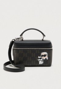 Melna ādas soma ar rāvējslēdzēja aizdari, uz kuras ir zīmēta karikatūras grafika ar cilvēku un kaķi. Komplektā ir noņemams plecu siksniņa.