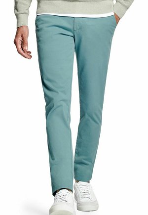 Lichtblauwe broek van een katoenmix met een slanke pasvorm, voorzien van een subtiele structuur en een witte tailleband, gecombineerd met witte sneakers.