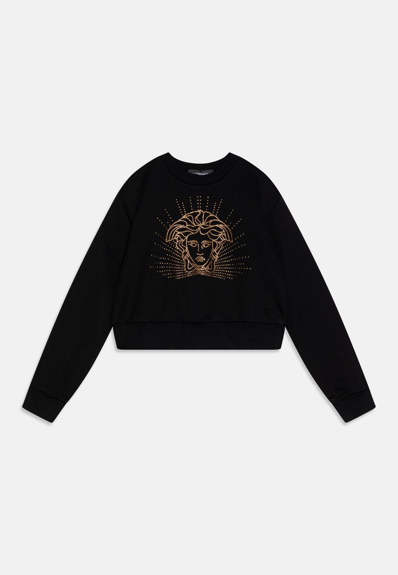 Sweatshirt curto preto com mangas longas, apresentando um gráfico de um rosto adornado com tachas douradas e linhas radiantes. Tecido macio, gola redonda.