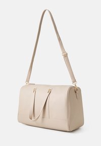 Beige leather tote bag with dual handles and an adjustable shoulder strap. Features gold-tone hardware and a smooth, textured finish.