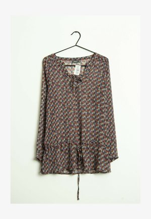 Blusa de manga larga con estampado floral, escote con cordones y cintura con cordón ajustable, colgada en una percha negra sobre fondo blanco.