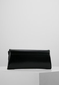 Czarna skórzana kopertówka o eleganckim prostokątnym kształcie, gładkiej fakturze oraz zwiniętym zamknięciu na górze. Minimalistyczny design z przeszyciami na górze.