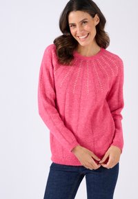 Maglione rosa lavorato a maglia con scollo rotondo, caratterizzato da linee verticali texturizzate e piccoli dettagli metallici lungo la paletta, che conferiscono una leggera lucentezza.