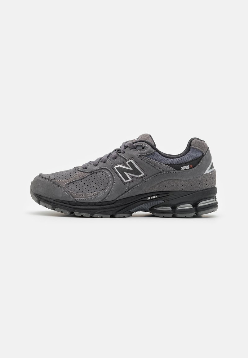 Chaussure de sport grise New Balance avec panneaux en mesh et daim, semelle noire rembourrée, logo "N" sur le côté.