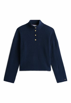 Marineblauer gerippter Pullover mit hohem Kragen, fünf Messingknöpfen am Hals und langen Ärmeln. Hat ein verkürztes Design und strukturiertes Material.
