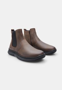 Boots de piele maro până la gleznă cu panouri laterale elastice și fermoar, având o talpă texturată din cauciuc și un finisaj neted.