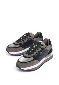 Sneaker grigi e neri realizzati con una combinazione di suede e materiali sintetici, forma arrotondata e suola in gomma bianca con dettaglio del logo.