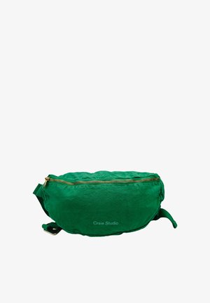 Sac banane en tissu vert avec fermeture éclair dorée et sangle réglable, étiqueté « Craie Studio », présenté sur fond blanc.