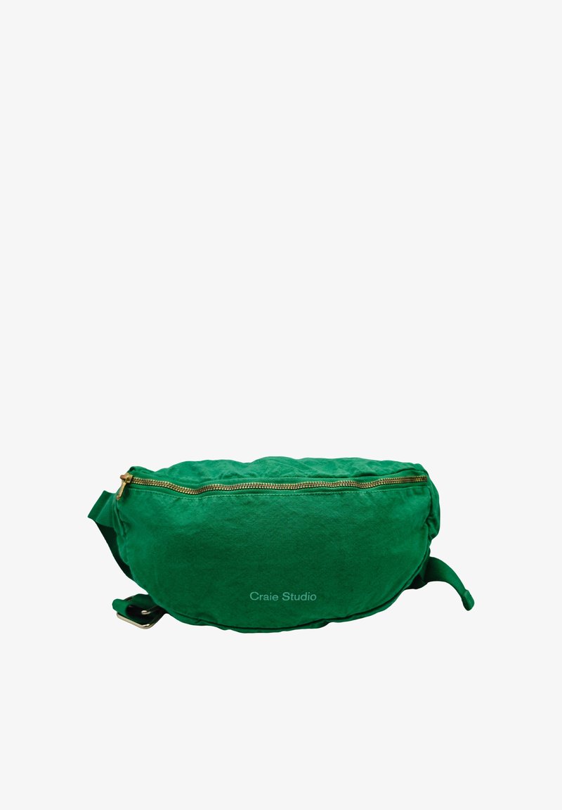 Sac banane en tissu vert avec fermeture éclair dorée et sangle réglable, étiqueté « Craie Studio », présenté sur fond blanc.