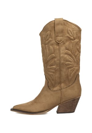 Bota de cowboy de ante marrón con punta afilada, costuras decorativas y un tacón de madera apilada. Presenta un caña alta y lengüetas de tirón.
