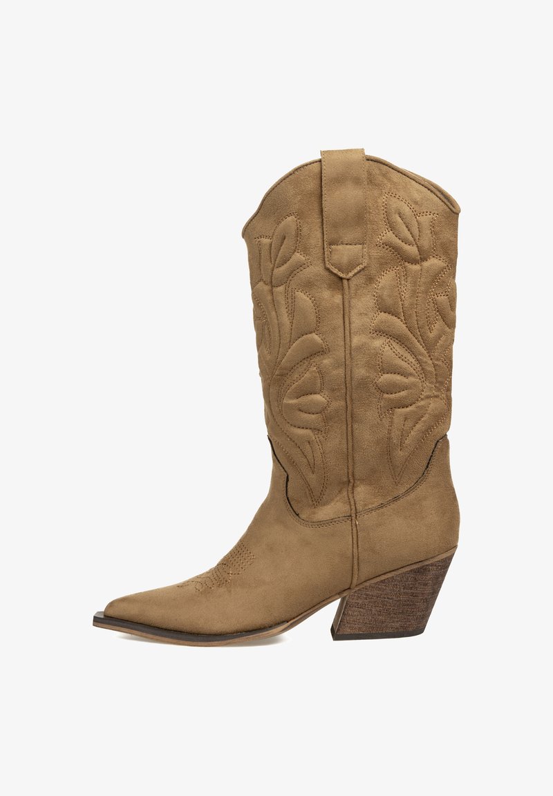 Bota de cowboy de ante marrón con punta afilada, costuras decorativas y un tacón de madera apilada. Presenta un caña alta y lengüetas de tirón.